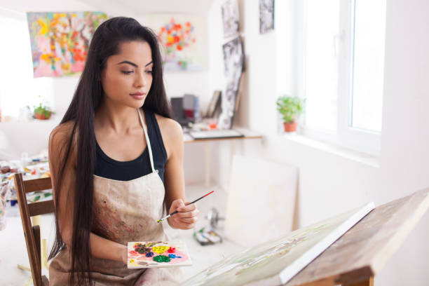 istock Beautiful young artist drawing in atelier 904384018