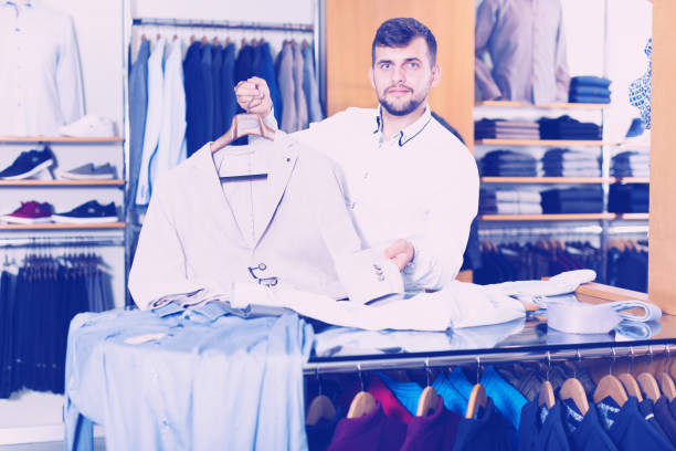 istock Young male shopping seller offering various jacket 904390626