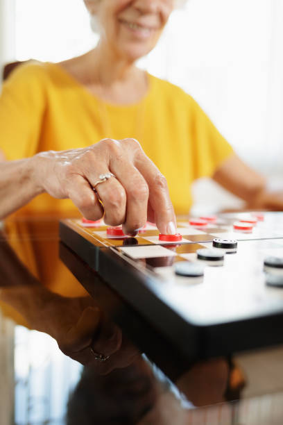istock Grandma Playing Checkers Board Game In Hospice 904396320