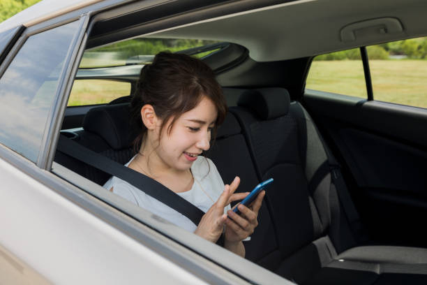 istock young woman using smart phone in the car. 904403562