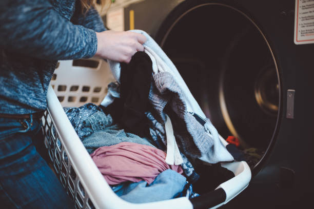 Close-up of a woman with a laundry basket washing clothes Close-up of a woman with a laundry basket washing clothes bonn photos stock pictures, royalty-free photos & images