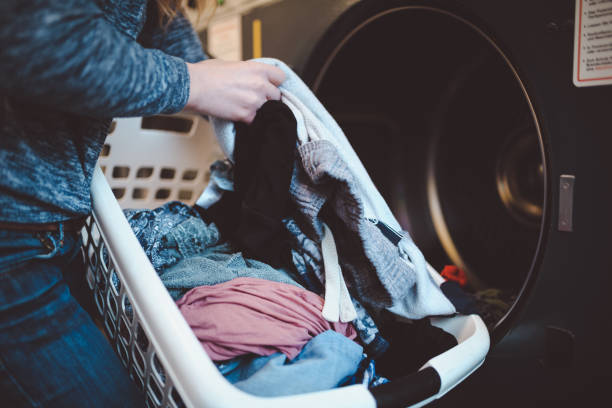 close-up de uma mulher com uma cesta de lavanderia, lavagem de roupas - laundromat clothes washer laundry utility room - fotografias e filmes do acervo