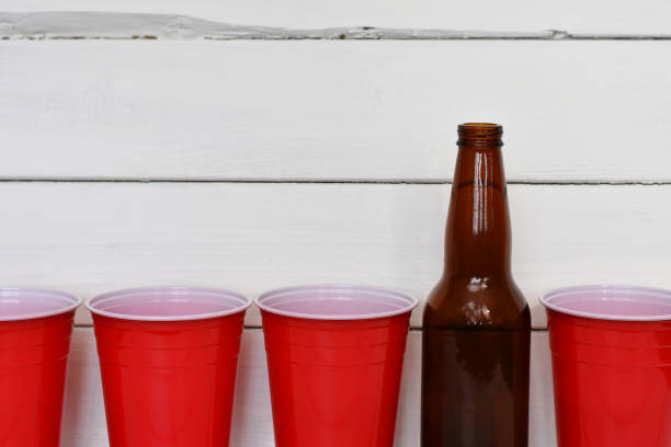 красные сольные чашки и пивные бутылки - disposable cup red beer plastic стоковые фото и изображения