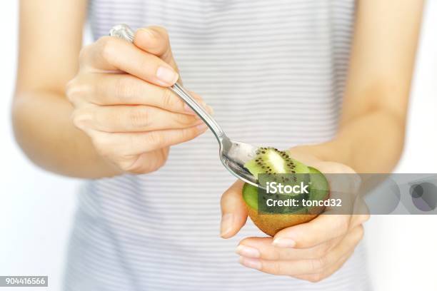 A Woman Hold Kiwi Fruit And Slice With Spoon For Eating On Isolated White Background Concept Of Nutrition Healthy Beauty And Diet Stock Photo - Download Image Now