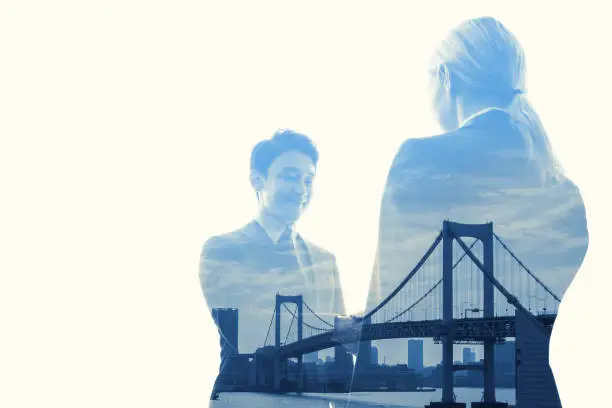 Photo of Double exposure of two business persons shaking hands and bridge, relationship conceptual abstract