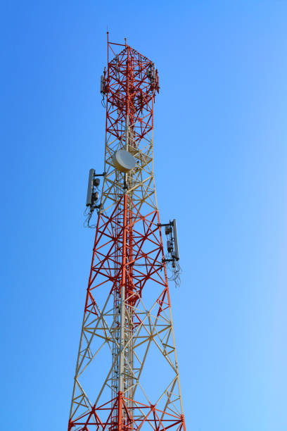 istock Mobile phone communication antenna tower with satellite dish on blue sky background 904424448