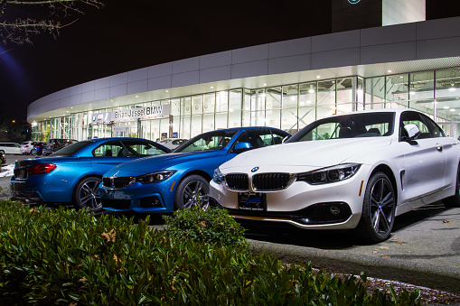 Vancouver BC, Canada - January 9, 2018: Office of official dealer BMW. BMW is a German automobile manufacturer specializing in high-performance and luxury cars. Night shot all is illuminated.