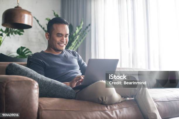 Young Asian Man Working At Home Stock Photo - Download Image Now - Laptop, Men, Domestic Life