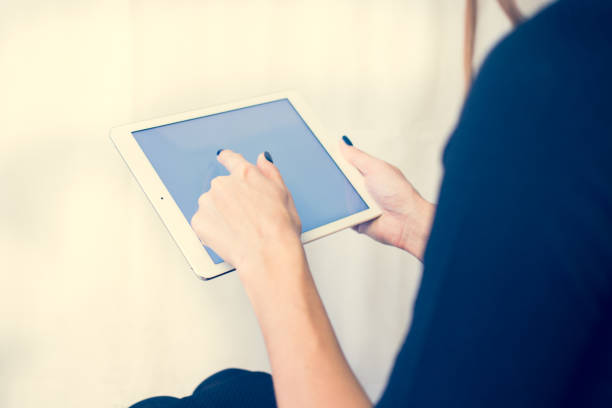 istock Girl on a tablet computer, browses the information. The white background and the screen 904442468