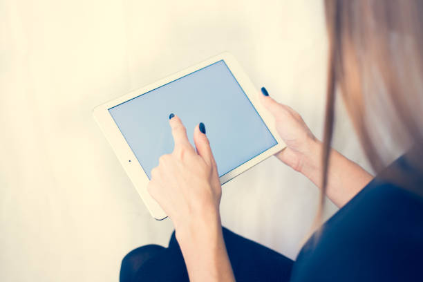 istock Girl on a tablet computer, browses the information. The white background and the screen 904442502