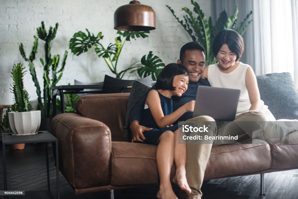 Familia asiática mirando la computadora en el hogar. - Foto de stock de Familia libre de derechos