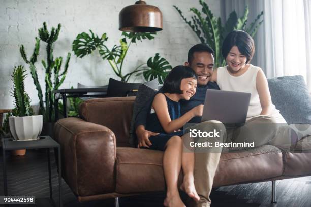Familia Asiática Mirando La Computadora En El Hogar Foto de stock y más banco de imágenes de Familia
