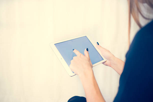 istock Girl on a tablet computer, browses the information. The white background and the screen 904442682