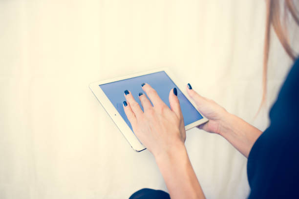 istock Girl on a tablet computer, browses the information. The white background and the screen 904444780