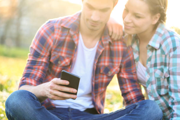 istock Young couple looking at mobile phone 904445376
