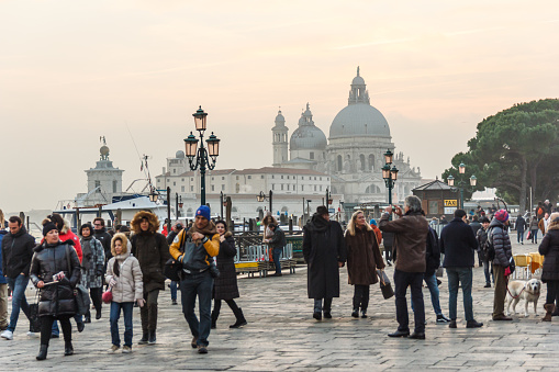 Venice, Italy - December 9, 2016: People at Venice with Basilica di Santa Maria della Salute at background.