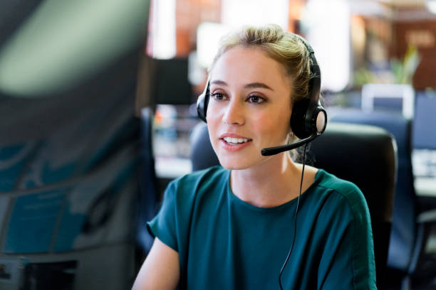 lächelnd geschäftsfrau tragen kopfhörer im büro - headset stock-fotos und bilder