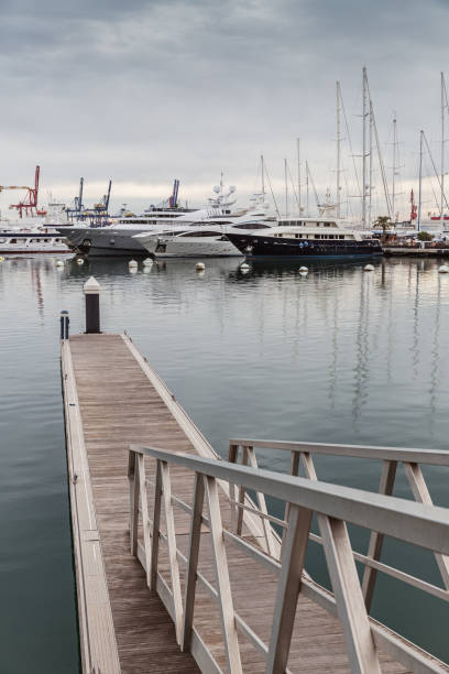 istock White yachts in harbor. Wooden pier. 904456892