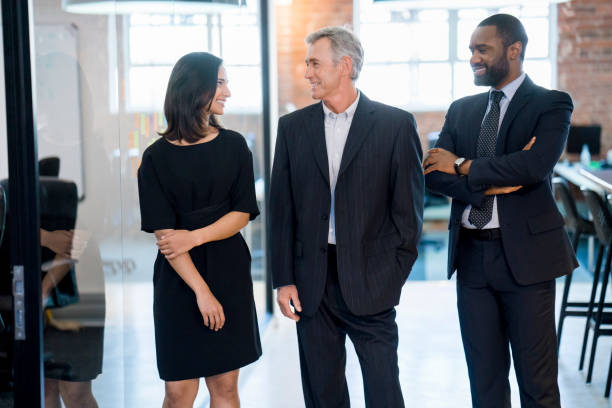 istock Smiling businessman discussing with coworkers 904457288
