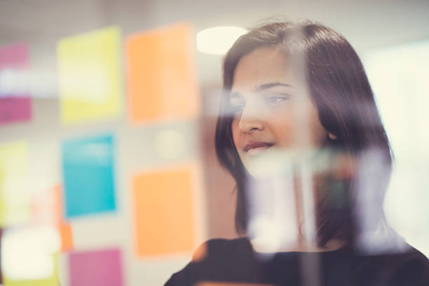 istock Smiling businesswoman looking at notes on glass 904460100