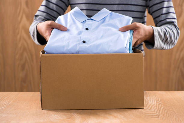 istock Donation box for poor with clothing in male hands 904464308