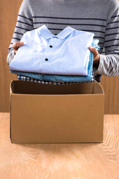 istock Donation box for poor with clothing in male hands 904464922