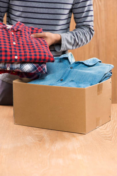 istock Donation box for poor with clothing in male hands 904465150