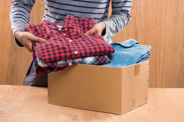 istock Donation box for poor with clothing in male hands 904465192