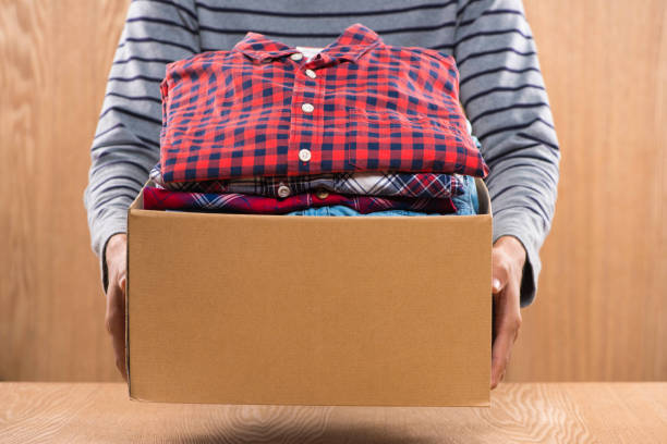 istock Donation box for poor with clothing in male hands 904465582