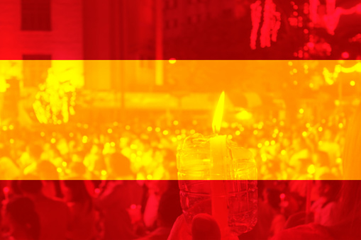 Color of Spain flag with people holding candle.