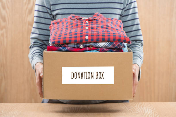 istock Donation box for poor with clothing in male hands 904466212