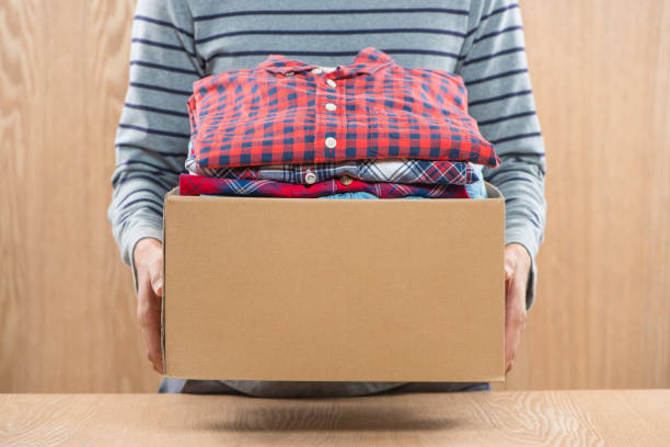istock Donation box for poor with clothing in male hands 904466226