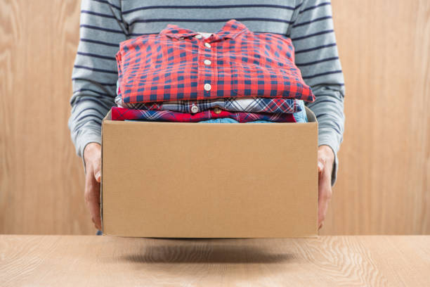 Donation box for poor with clothing in male hands