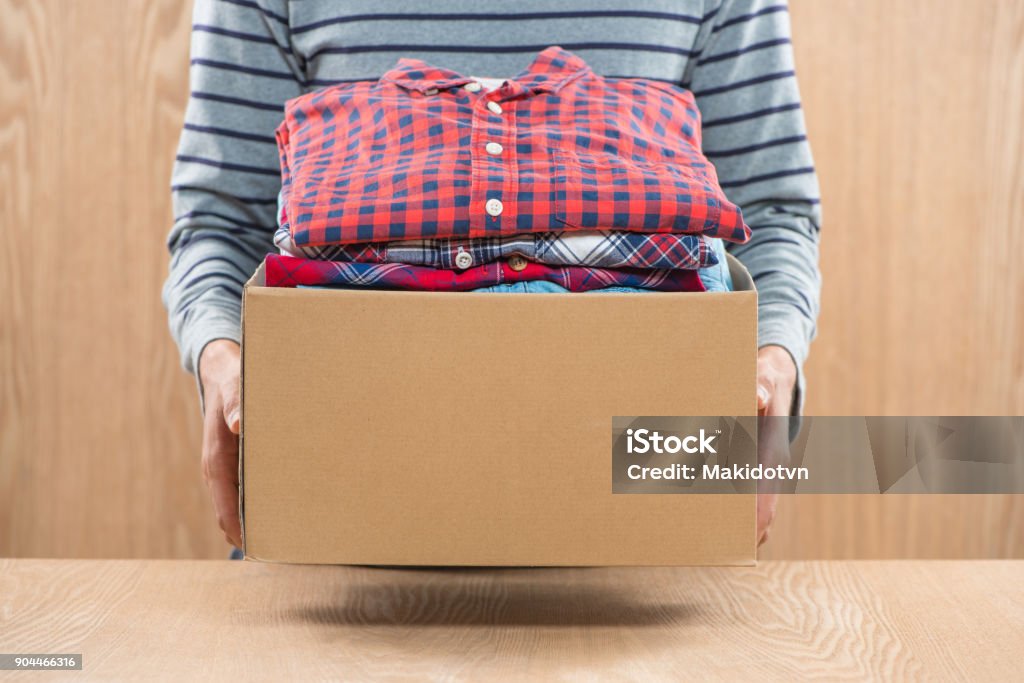 Donation box for poor with clothing in male hands Charitable Donation Stock Photo