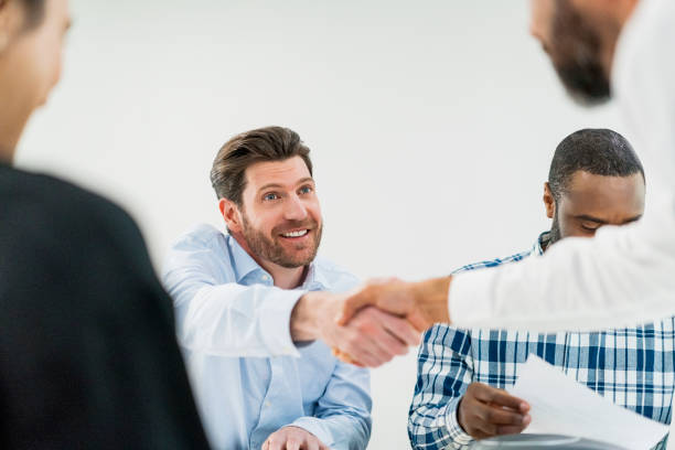 istock Smiling business people shaking hands in meeting 904469242