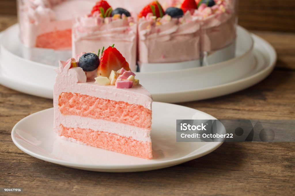 Gâteau yaourt à la fraise chocolat blanc décoré avec des fruits frais et des morceaux de chocolat sur la table en bois. Gâteau rose délicieux et doux pour la Saint-Valentin ou la fête d’anniversaire. Concept de boulangerie maison. - Photo de Pâtisserie libre de droits