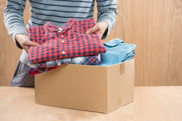 istock Donation box for poor with clothing in male hands 904472984
