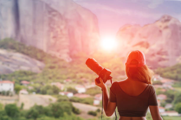 istock Female in red cap with camera take a picture sunset in mountain. 904475858