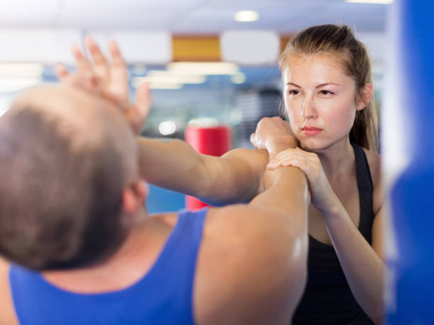 istock Girl and her trainer are practicing punches in gym 904476326
