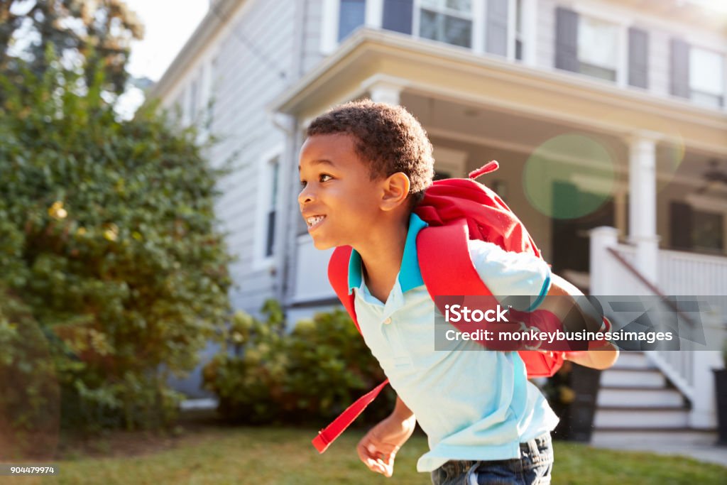Young Boy Leaving House To Walk To School Child Stock Photo