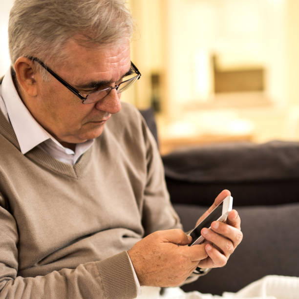 istock Senior man text messaging on cell phone while relaxing at home 904481986
