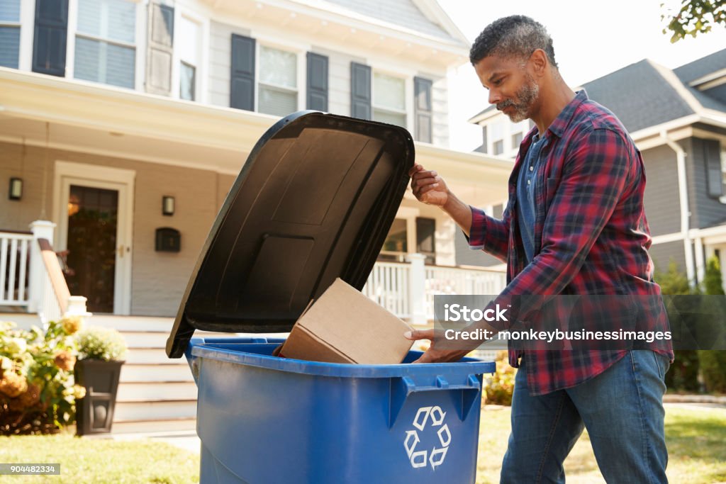 Man Filling Recycling Bin On Suburban Street Recycling Stock Photo