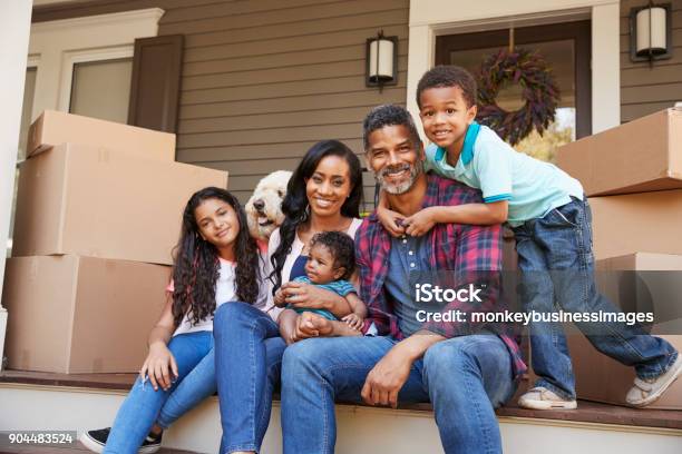 Family With Children And Pet Dog Outside House On Moving Day Stock Photo - Download Image Now