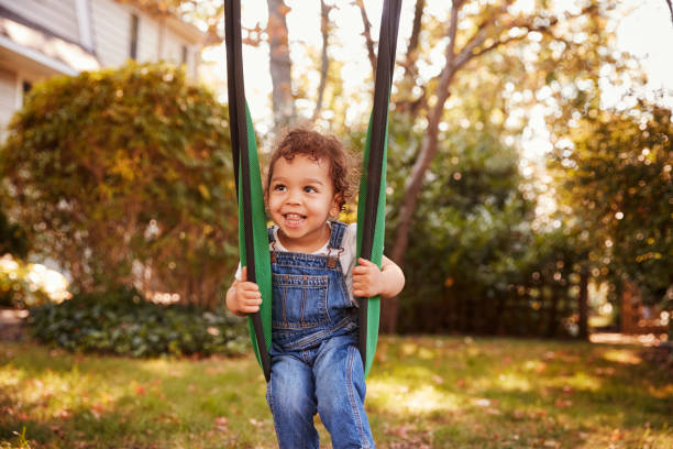 istock Happy Young Girl Playing On Garden Swing 904485978