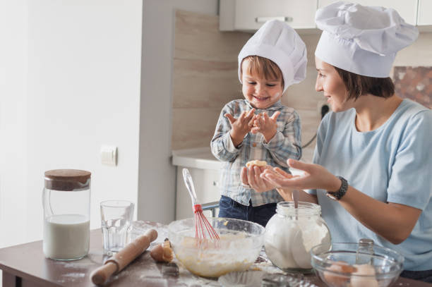 istock happy beautiful mother and child preparing dough at kitchen 904486322