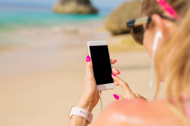 istock Woman using smartphone on the beach 904487188