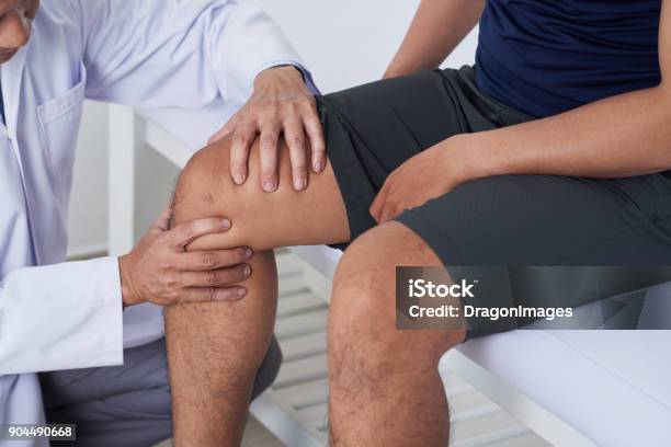 Examining Knee Stock Photo - Download Image Now - Knee, Pain, Medical Exam