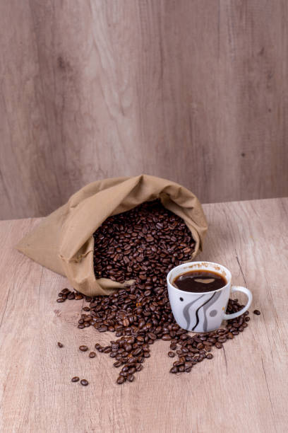istock Spilled coffee beans and a fresh cup of coffee 904498344