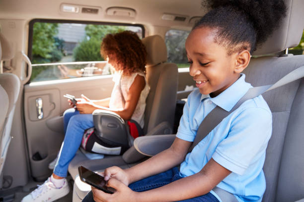 Children Using Digital Devices On Car Journey Children Using Digital Devices On Car Journey vehicle seat stock pictures, royalty-free photos & images
