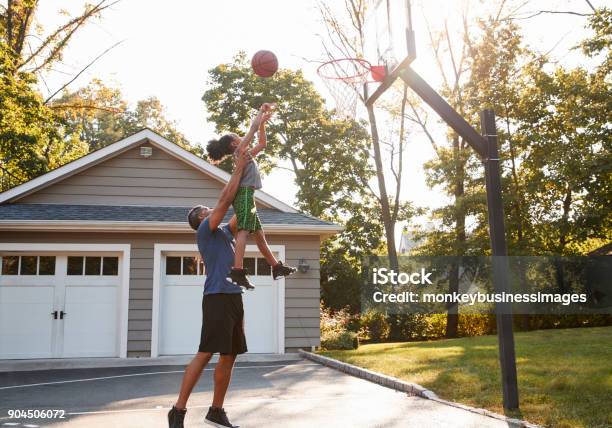 Father And Son Playing Basketball On Driveway At Home Stock Photo - Download Image Now
